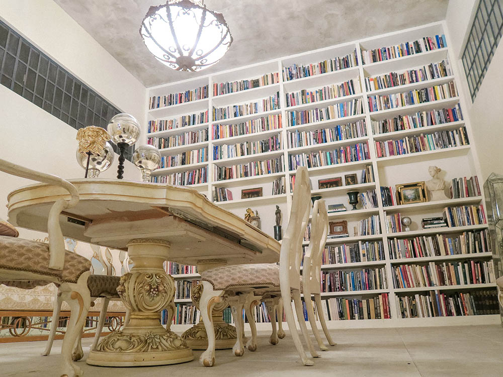 Decorate walls from floor to ceiling with bookshelves, and in the centre, a crystal hanging ceiling lamp